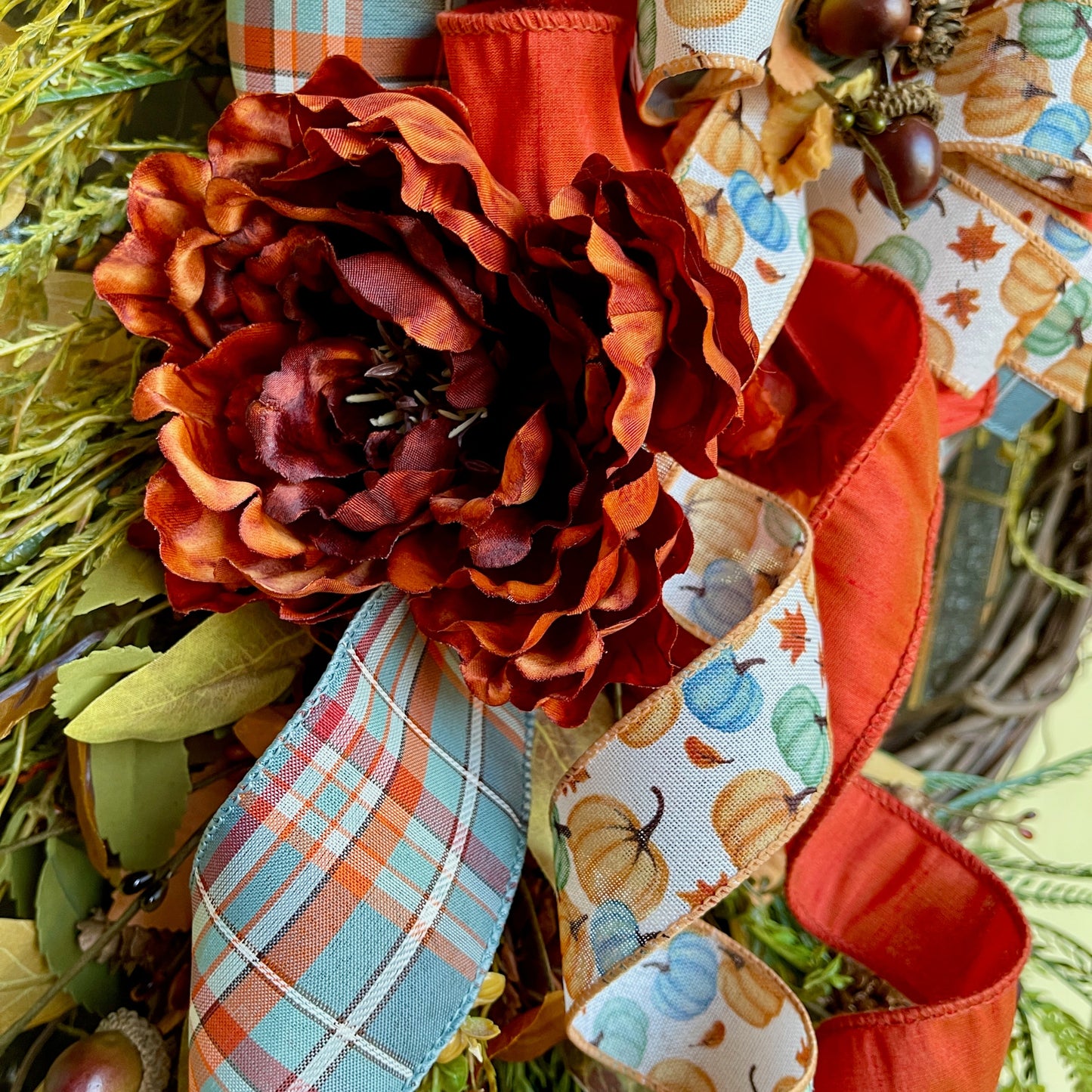 Decorative wreath with autumn-themed ribbons and flowers
