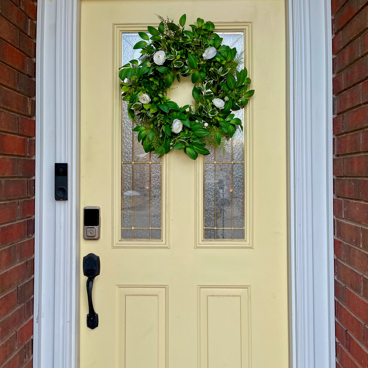Handcrafted lush greenery front door wreath with white roses. Elegant farmhouse decor perfect for spring, summer, and year-round display.