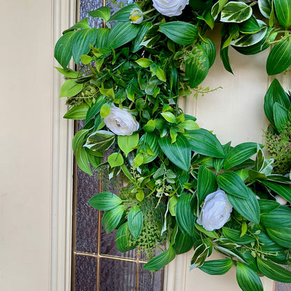 Handcrafted lush greenery front door wreath with white roses. Elegant farmhouse decor perfect for spring, summer, and year-round display.