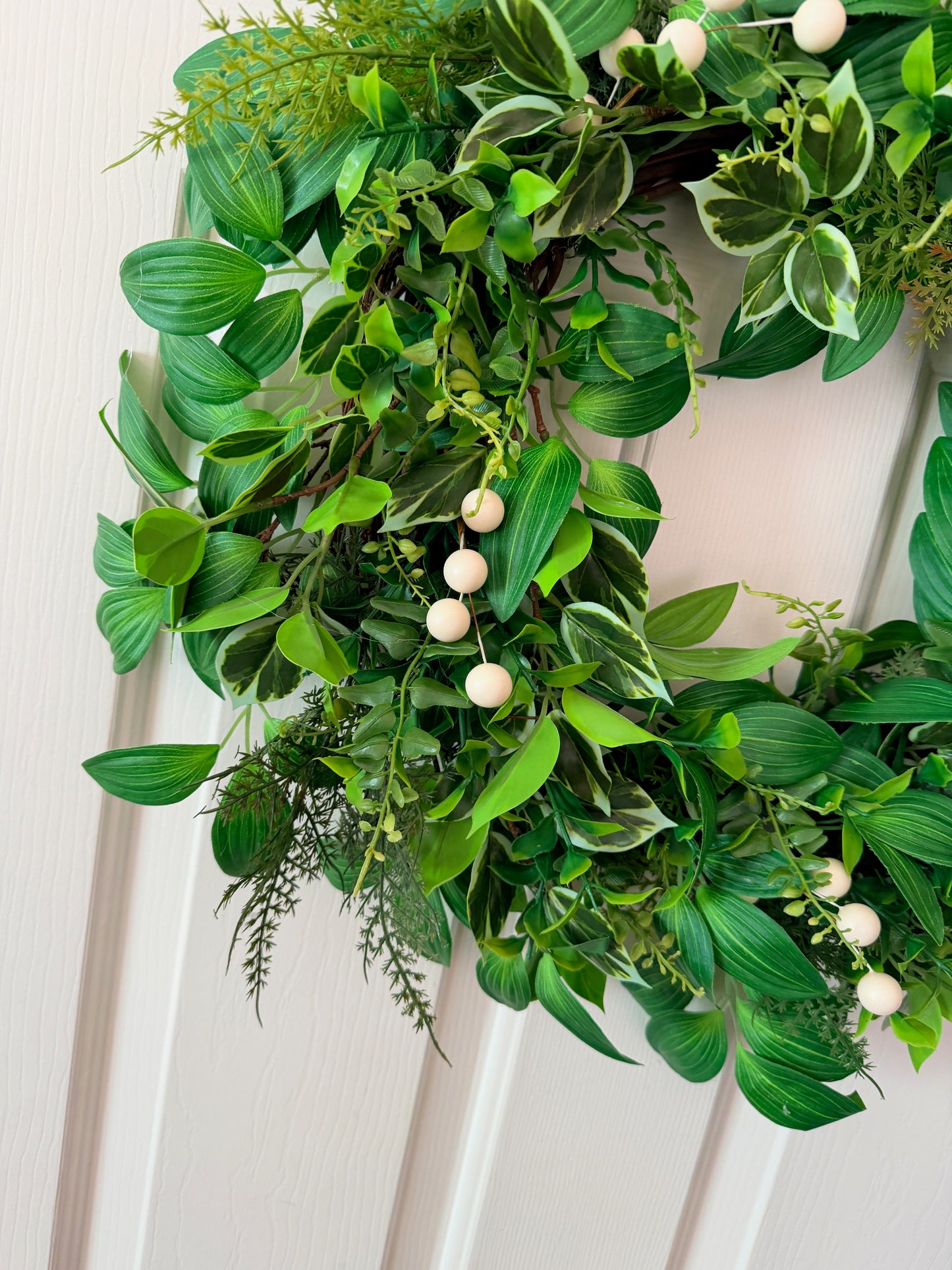 Handcrafted lush greenery front door wreath with white roses. Elegant farmhouse decor perfect for spring, summer, and year-round display.