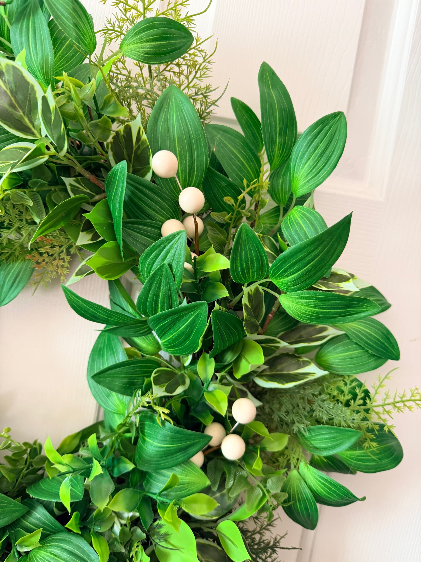 Handcrafted lush greenery front door wreath with white roses. Elegant farmhouse decor perfect for spring, summer, and year-round display.