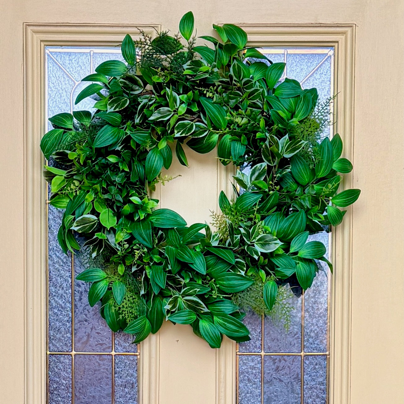 Handcrafted lush greenery front door wreath with white roses. Elegant farmhouse decor perfect for spring, summer, and year-round display.