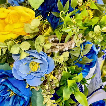 Decorative wreath with blue, yellow, and green flowers and leaves.