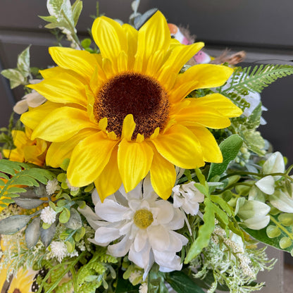 Bouquet of sunflowers and daisies with greenery on a dark background