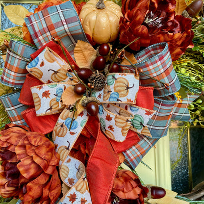 Decorative bow with autumn-themed ribbons and pumpkins on a floral background