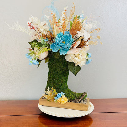 Decorative boot filled with flowers on a wooden surface