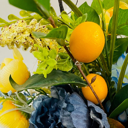Decorative arrangement with lemons, flowers, and fabric on a white background