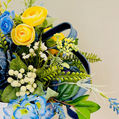 Bouquet of artificial flowers with blue, yellow, and green colors on a beige background