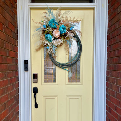 Decorative wreath with flowers on a yellow door with a brick wall background