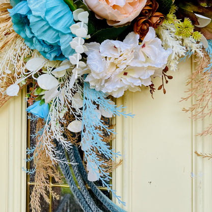 Decorative wreath with flowers and greenery on a door