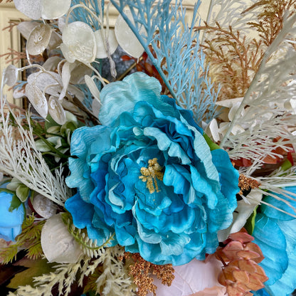 Decorative wreath with blue flowers, seashells, and coral.