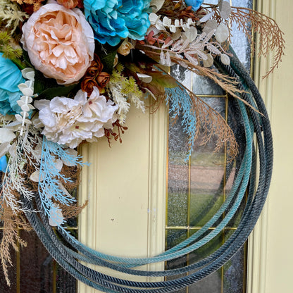 Decorative lariat rope wreath with flowers and rope on a door