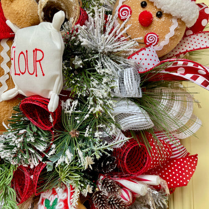 Christmas wreath with gingerbread man, reindeer, and festive ribbons on a yellow background