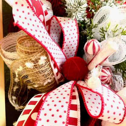 Close-up of a decorative bow with red and white polka dot ribbon on a Christmas-themed background.